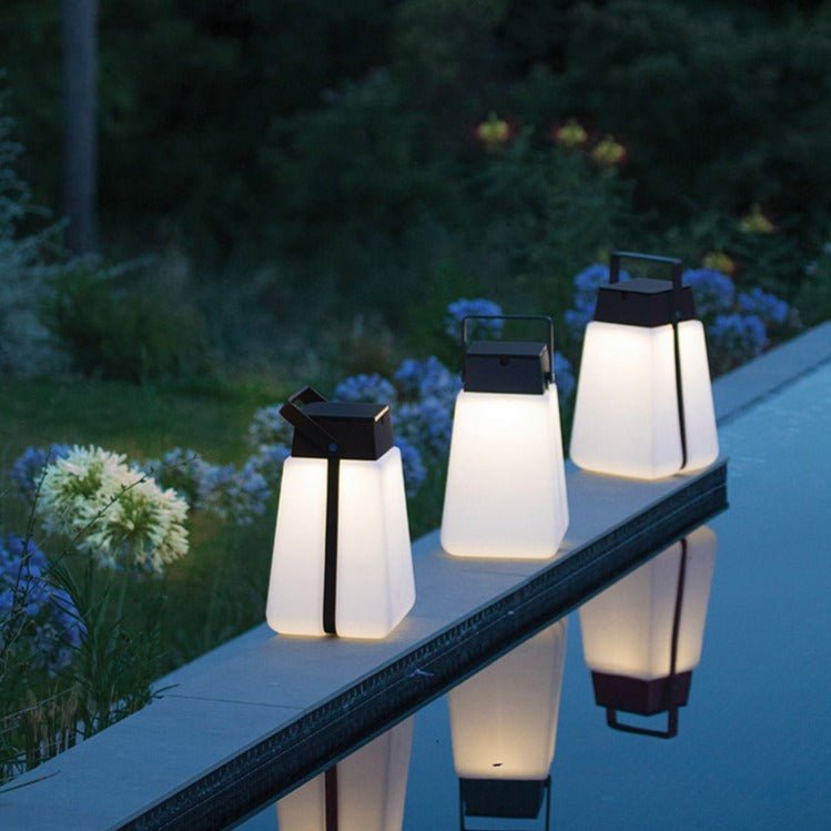 Three Junam Lights reflecting in pool at night